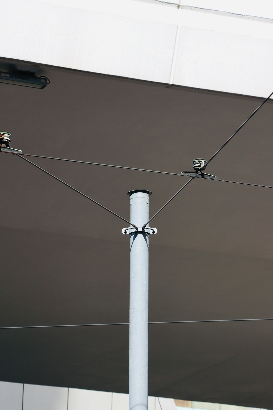 A white pole supports overhead wires